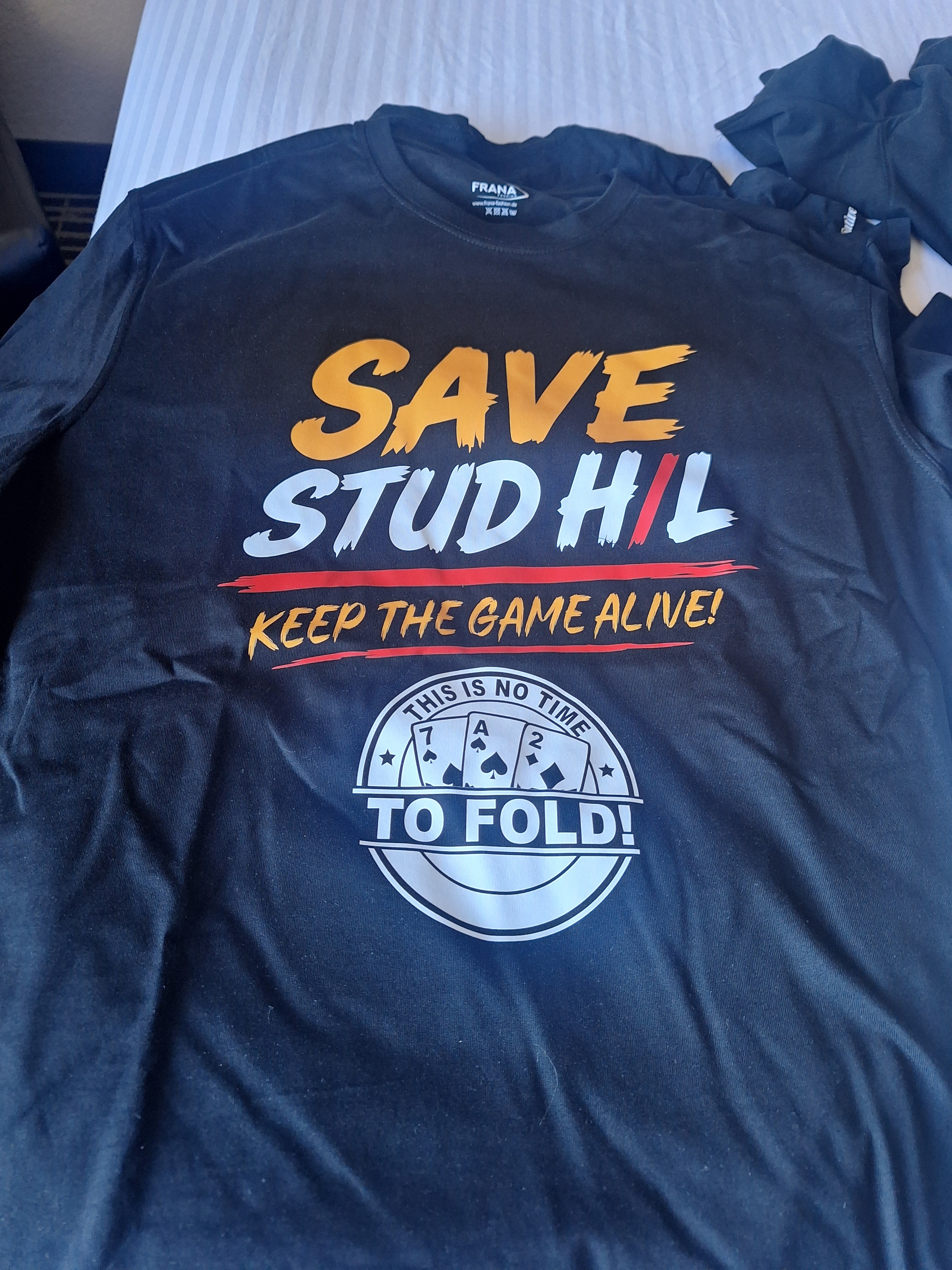 The Save Stud H/L t-shirt reading 'Keep the game alive! This is no time to fold!' with a 7-A-2 card badge