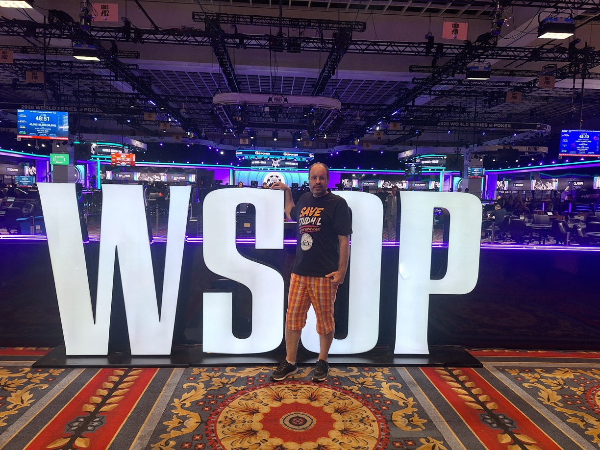 The author standing in front of the giant illuminated WSOP letters, wearing the Save Stud H/L shirt